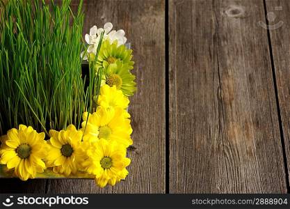 Grass and flowers over wooden table