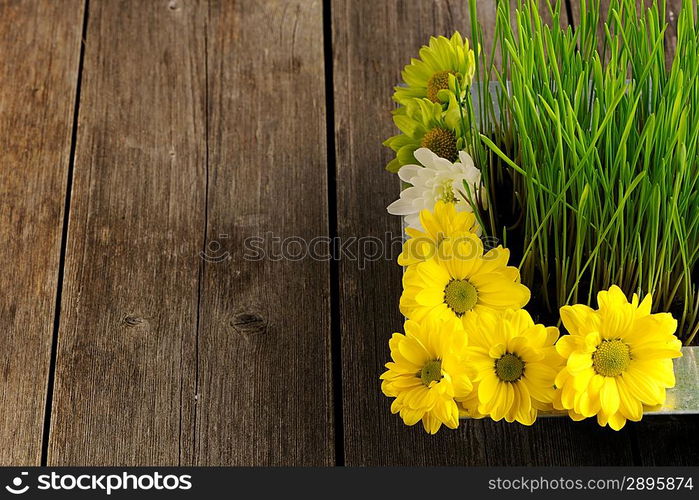 Grass and flowers over wooden table