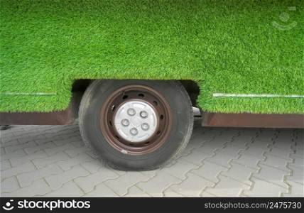 Grass covered car and wheel. Element of design.