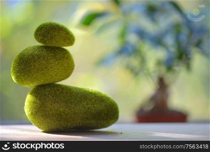 Grass green stack of pebble stones on table