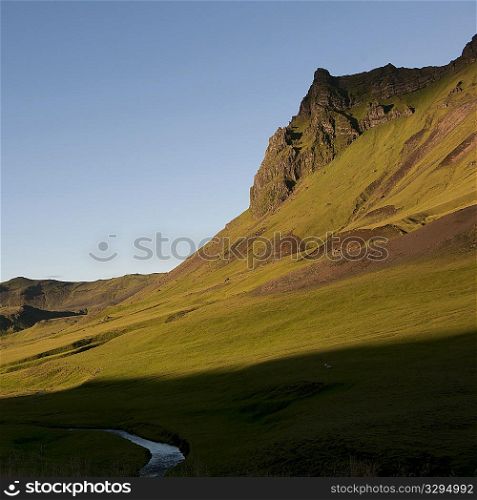 Grassland in mountain valley with stream