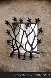 grate on the window in the form of blooming flowers