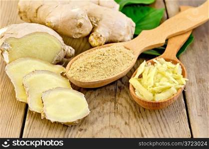 Grated and ground ginger in two wooden spoons, ginger root, green leaves on the wooden board