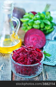 grated beet in bowl and on a table