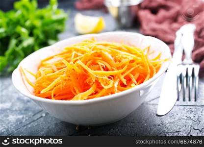 grated carrot in bowl and on a table