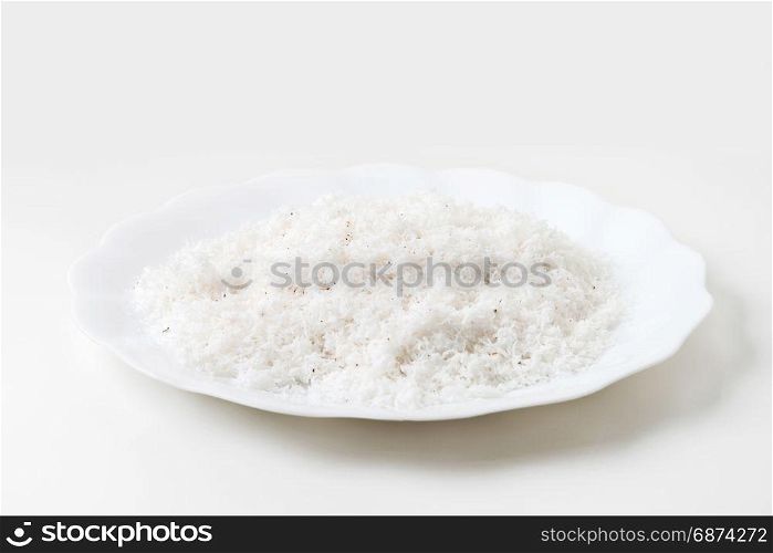 grated coconut in dish isolated on white