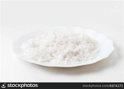 grated coconut in dish isolated on white
