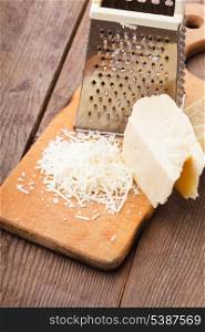 Grated Parmesan cheese with grater on a table
