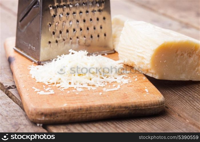 Grated Parmesan cheese with grater on a table