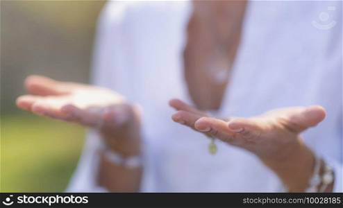 Gratefulness - Woman expressing gratitude with hands. Close up image of female hands in prayer position outdoor. Self-care practice for wellbeing. Gratefulness Meditation Hand Gesture
