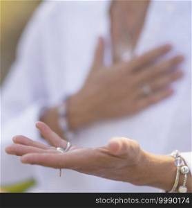Gratefulness - Woman expressing gratitude with hands. Close up image of female hands in prayer position outdoor. Self-care practice for wellbeing. Gratefulness Meditation Hand Gesture