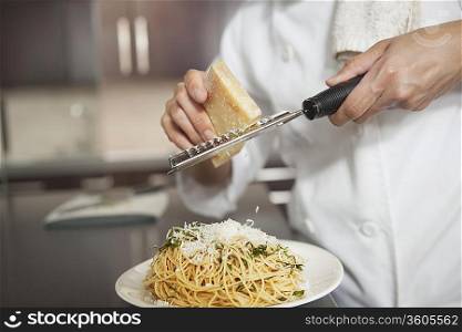 Grating parmesan onto spaghetti