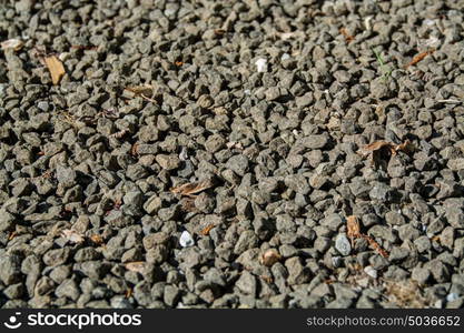 gravel background, grey gravel rocks and some brown old leaves