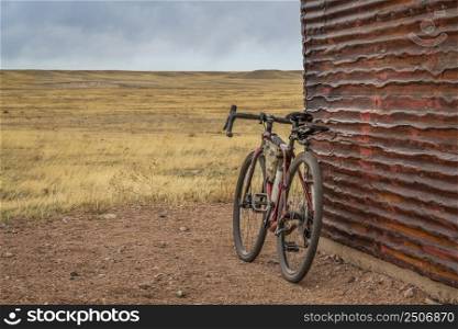 gravel bike at old corrugated metal barn in Colorado countryside - early spring scenery of Soapstone Prairie Natural Area near Fort Collins