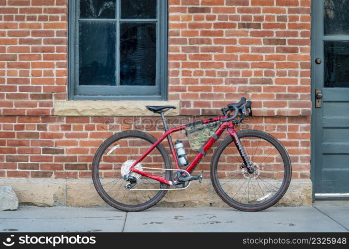 gravel bike with lightweight carbon frame and wireless drivetrain against old brick building wall