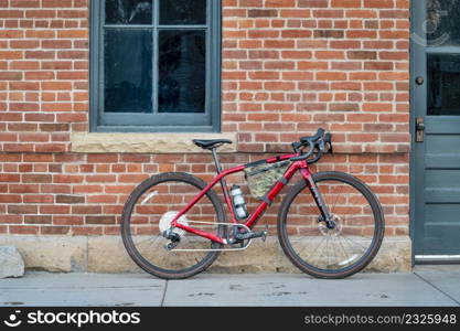 gravel bike with lightweight carbon frame and wireless drivetrain against old brick building wall