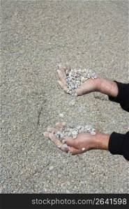 gravel rolling stones falling man hands in quarry background