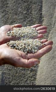 gravel sand in man hands in quarry showing camera