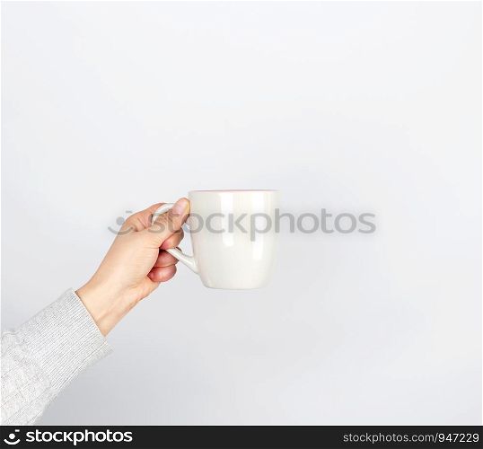 gray ceramic cup in female hand on a white background, hand raised up
