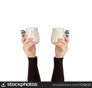 gray ceramic cup in female hand on a white background, hands raised up, copy space