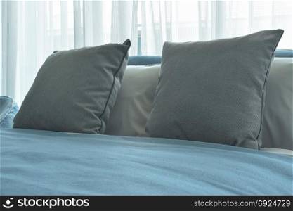 Gray color pillows on bed with blue blanket in modern bedroom