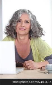 Gray-haired woman in front of laptop computer