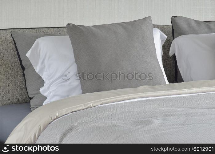 Gray pillow on white setting on bed with comfy blanket