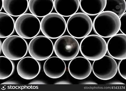 gray PVC tubes plastic pipes stacked in rows pattern