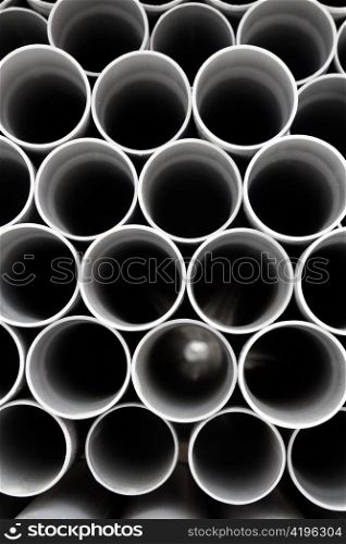gray PVC tubes plastic pipes stacked in rows pattern