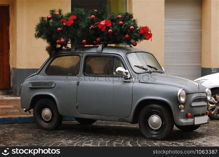 gray retro car with Christmas tree decorated with red layers and butterflies. View of a red retro car with Christmas tree. Winter. Christmas. christmas car. View of a red retro car with Christmas tree. Winter. Christmas. gray retro car with Christmas tree decorated with red layers and butterflies. christmas car