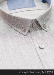 gray shirt with a focus on the collar and button, close-up. cotton shirt, close-up