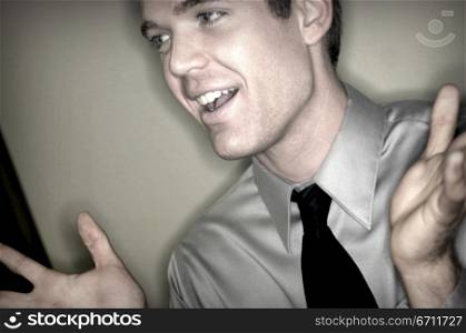 Gray shirted businessman is holding up both his arms in confusion and shrugs