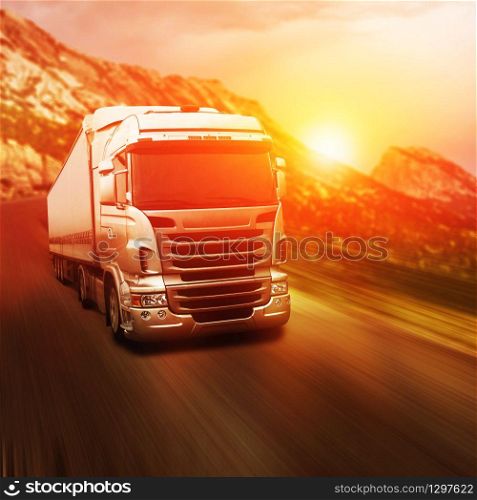 Gray truck on highway road at sunset