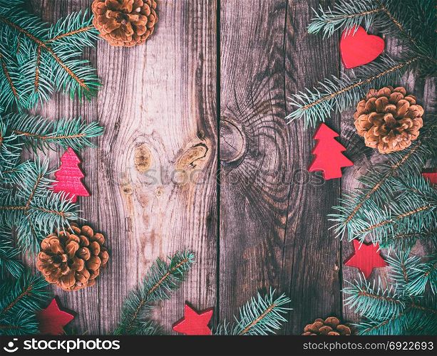 gray wood background with green spruce branches and Christmas decor, empty space in the middle