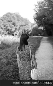 Grayscale photo of a woman walking by a path through the forest