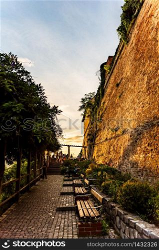 Graz, Austria - 17.08.2019 : View at famous Castle at Schlossberg hill and benches. Above Graz city during sunset in summer. Travel destination. View at famous Castle at Schlossberg hill and tourists. Above Graz city during sunset in summer