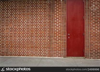 Great background of a garage of orange bricks with a red door