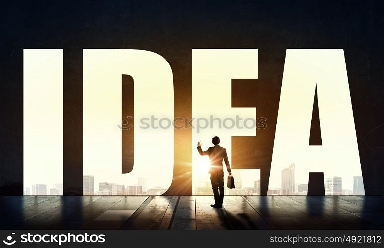 Great bright idea for success. Back view of businessman standing in light of word idea