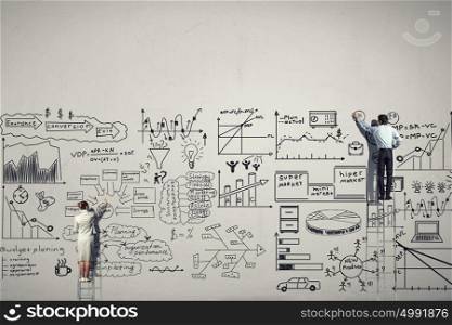 Great business strategy. Back view of businessman and woman standing on ladder and drawing sketch on wall