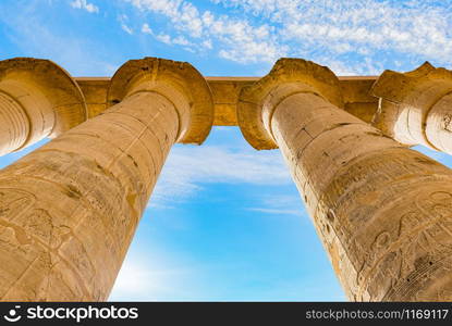 Great columns in Karnak Temple of Luxor and blue sky. View from below. Columns from below