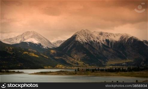 Great for themes of nature, travel, wilderness, seasons, weather, mountains, exploration, outdoor recreation, adventure. Nice Colorado Sunset with Lake Reflections and dramatic early fall snowstorm.