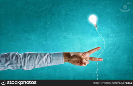 Great idea. Close up of hand and glowing light bulb