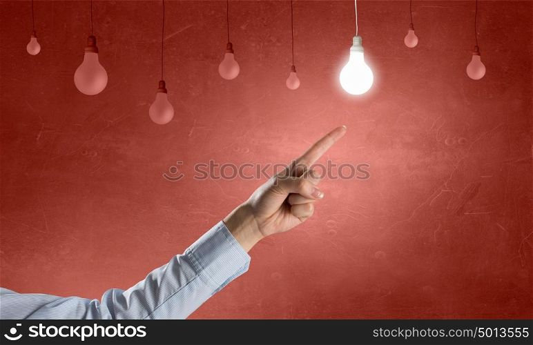 Great idea. Close up of hand pointing with finger at light bulb