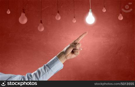 Great idea. Close up of hand pointing with finger at light bulb