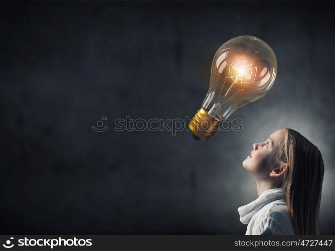 Great idea. Girl of school age looking above at light bulb