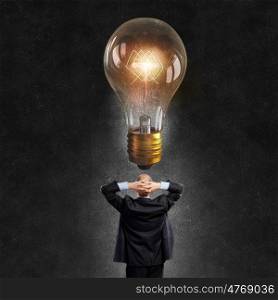 Great idea. Young businessman and glass glowing light bulb above his head