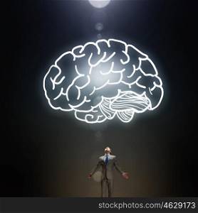 Great mental ability. Businessman with hands spread wide and human brain above his head
