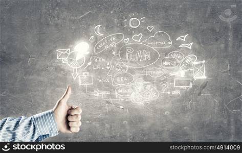 Great plan. Businessman hand showing thumb up to sketched plan on wall