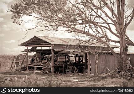 great red sepia image of an old farm shed building