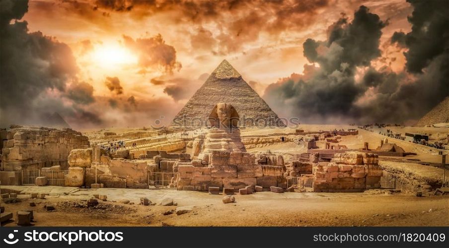 Great sphinx and pyramid and storm clouds